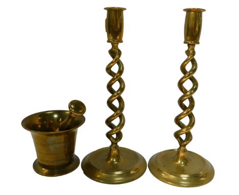 A brass pestle and mortar, the mortar 9cm high, together with a pair of brass candlesticks each with a double barley twist st