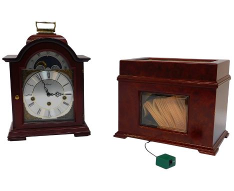 A Hermle mahogany cased mantel clock, the silvered dial bearing Roman numerals, moon phase, with brass spandrels, eight day, 