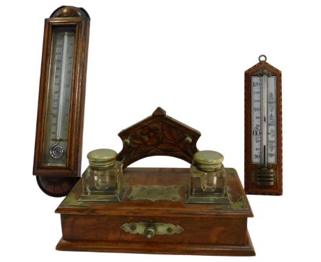 A late 19thC oak and silver plated ink stand, the raised back with rest for pens, the top with two inkwells, with hinged lids