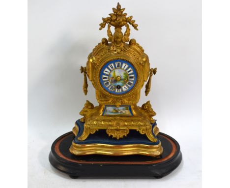 A French gilt metal and porcelain panelled mantel clock with 8-day movement, raised on an ebonised oval base (lacking glass d