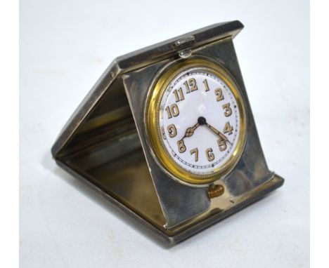 A travel watch - the 3.5 cm enamel dial with luminous hands and numbers, in folding silver case with engine-turned decoration