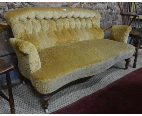 A Victorian walnut and part steel framed button backed open arm sofa of serpentine form, raised on turned front legs to ceram