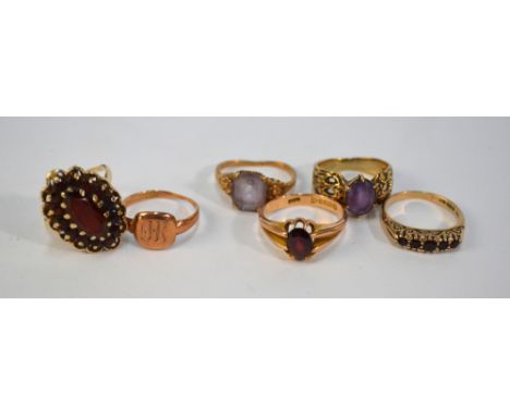 A collection of four 9ct stone set rings including oval garnet cluster, garnet single stone, garnet five stone, amethyst sing