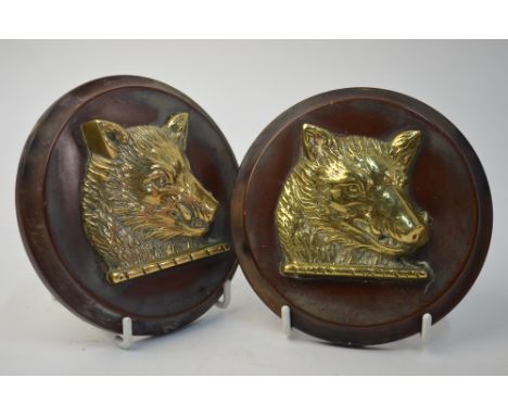 A pair of Naval 4.5in gun tampions, mounted with brass boar's heads on composite backs