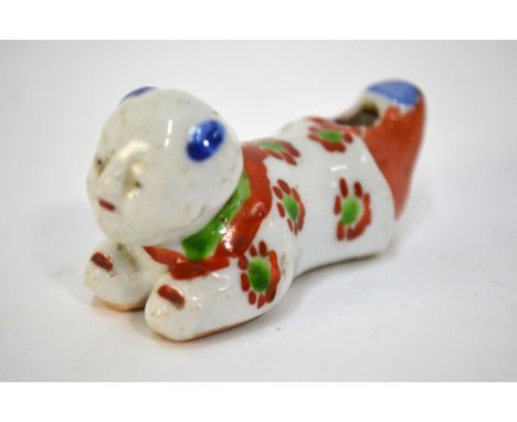 A scarce porcelain whistle designed as a recumbent karako with unglazed base; decorated in blue, green and copper red with bl