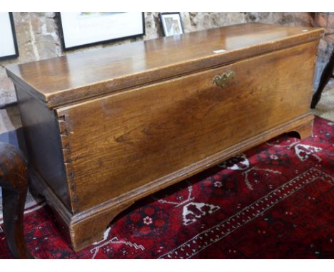 An antique oak six plank trunk, raised on shaped bracket feet 109 cm wide x 36 cm x 43 cm high