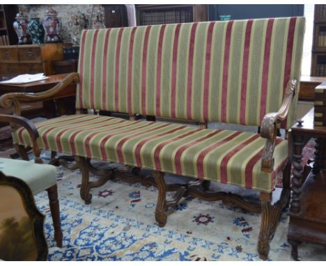 An Italian carved and moulded walnut framed upholstered settle/sofa in the 18th century style, raised on six scrolled legs un
