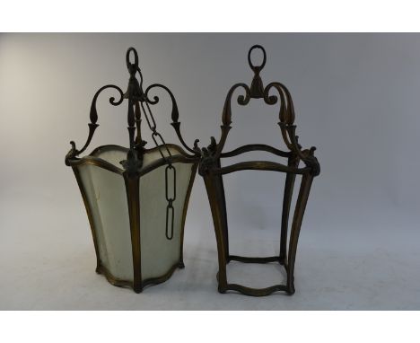 A pair of old patinated gilt framed hanging lanterns with shaped glass panelled sides, in the Italianate style, 54 cm high ov