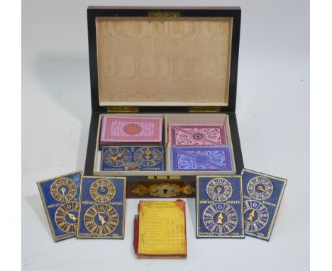 A Victorian walnut playing cards box, the domed lid mounted with brass and ivorine, containing part sets of Goodall & Son, Lo