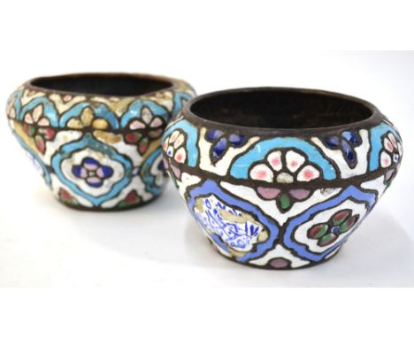 An associated pair of of copper and enamel bowls, possibly Syrian, each one decorated in white, blue, pink and green enamel w