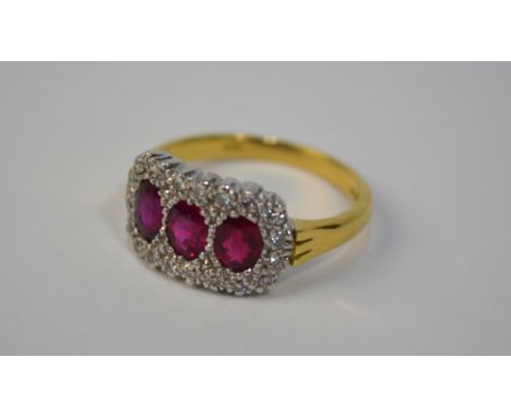 A ruby and diamond triple cluster ring, 18ct yellow and white gold setting, size M, approx 5.2g all in