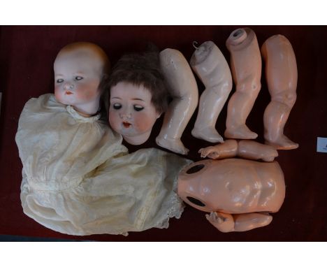 An Armand Marseille 995 A.4.M. bisque-headed girl doll with cropped brown wig, closing blue eyes and open mouth with two teet