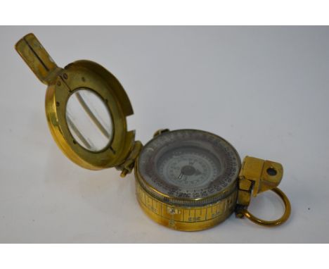 A brass field compass with mother-of-pearl dial, stamped 'T. G. Co. Ltd., London No.891790 (Broad Arrow) 1941 Mk III