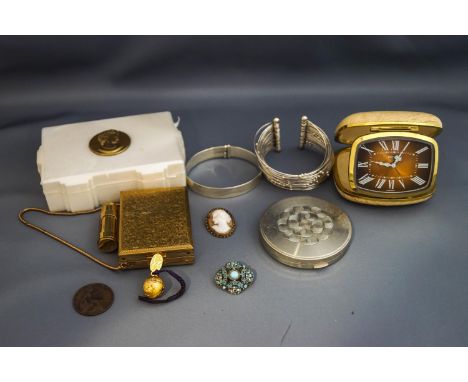 A silver bangle; another bangle; two compacts, a travel clock, a box and other items