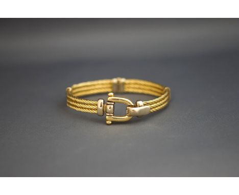 A two colour hinged bangle, marked 585, with a stirrup catch, 31 g gross
