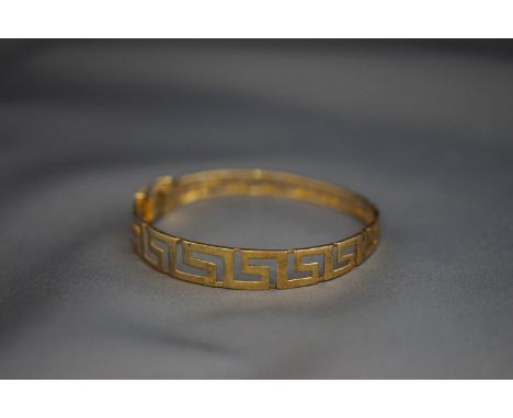 A hinged bangle, stamped '585', of Greek key design, 12.8 g gross