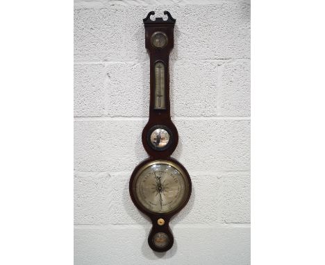 An Edwardian mahogany wheel barometer with dry/damp dial above a convex mirror, silvered main dial and spirit level, inscribe