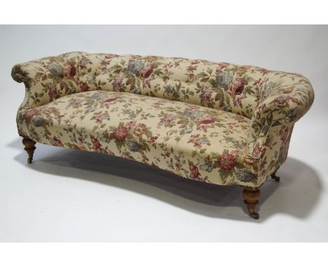 A Victorian sofa with low button back on turned legs with brass casters, 196cm wide