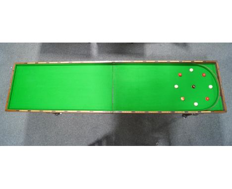 A Victorian mahogany folding bagatelle board with table base, with nine ivory balls, some painted, base 83cm high x 245cm lon