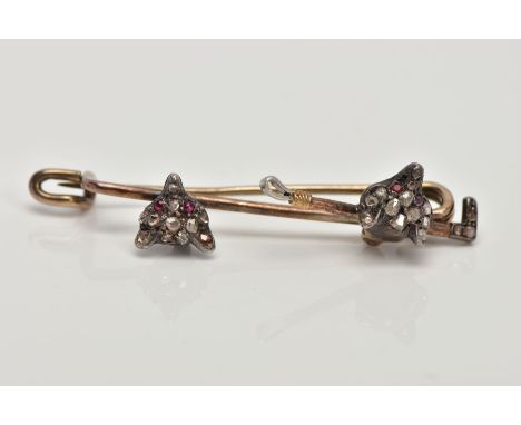 A YELLOW METAL FOX HEAD BAR BROOCH, designed with two fox heads set with rose cut diamonds and ruby set eyes, one also set wi