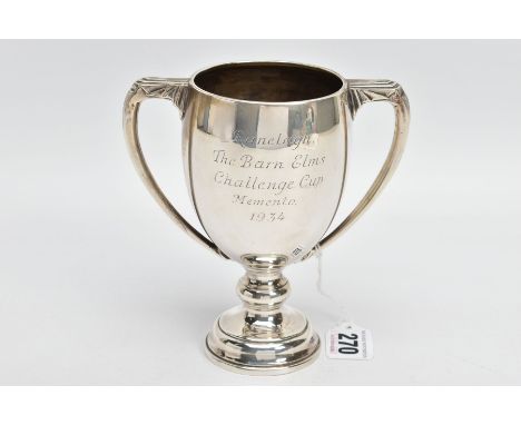 A SILVER TROPHY CUP, engraved 'Ranelagh, the Barn Elms Challenge Cup memento 1934', fitted with double handles, on a circular