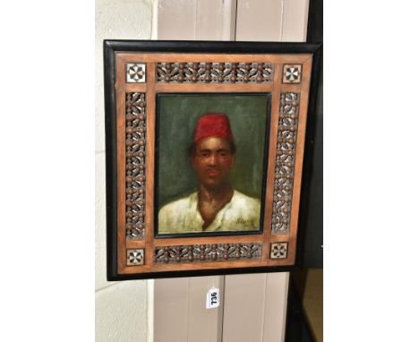 A HEAD AND SHOULDERS PORTRAIT OF A NORTH AFRICAN MALE WEARING A FEZ, indistinctly signed 20th Century school, Mashrabiya pane