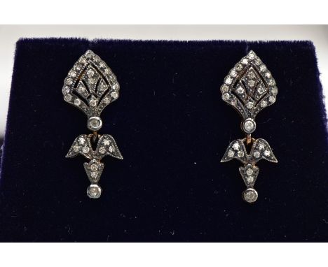 A PAIR OF YELLOW METAL DIAMOND DROP EARRINGS, each of an art deco style set with a small round brilliant cut diamond and sing