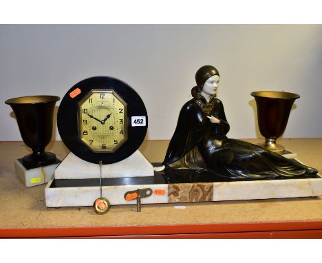 AN ART DECO ONYX, MARBLE, BRONZED SPELTER AND IVORY CLOCK GARNITURE, the clock with reclining female figure beside a shaped o