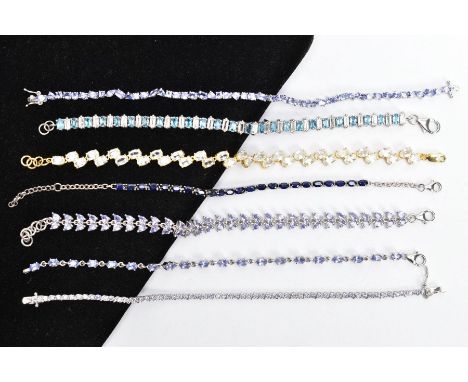 SEVEN GEM SET LINE BRACELETS, such as a white metal line bracelet set with twenty-three claw set, oval cut blue sapphires, fi