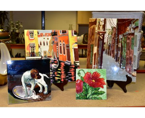 FOUR DECORATIVE CERAMIC TILES, comprising four tube lined, hand painted tiles with attached stand or hanging hook, decorated 