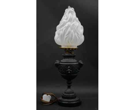 A 19th century embossed metal oil lamp converted to electricity with a later opaque flaming torch shade. H.56cm 