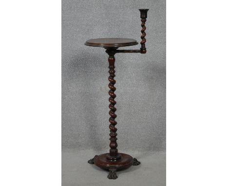 A 19th century mahogany night stand with swing action barley twist candlestick and pedestal support on lion's paw carved plat