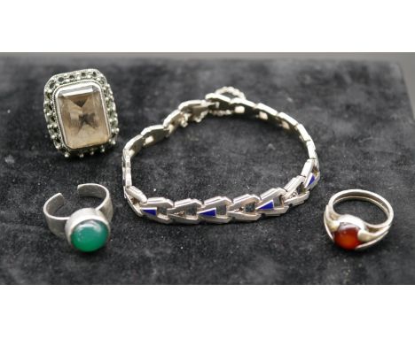 An Art Deco articulated silver and blue enamel bracelet set with marcasite along with three silver gem set rings. One set wit