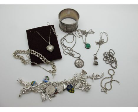 A Hallmarked Silver Curb Link Bracelet, suspending numerous novelty charms, including enamel souvenir shields (various stamps