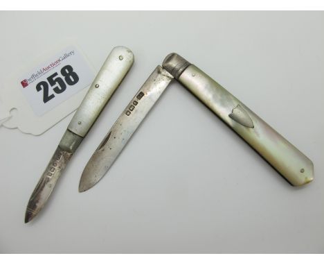A Hallmarked Silver and Mother of Pearl Folding Fruit Knife, together with a smaller example. (2) 