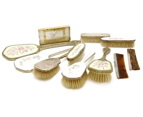 A silver and enamel three piece dressing table set, Birmingham 1969, together with a silver three piece dressing table set, o