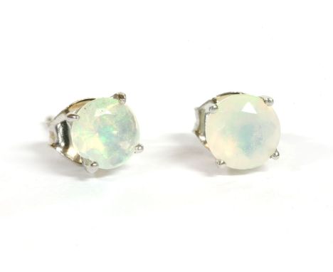 A pair of white gold single stone opal stud earrings, a circular faceted cut opal, claw set to a post and butterfly fitting, 