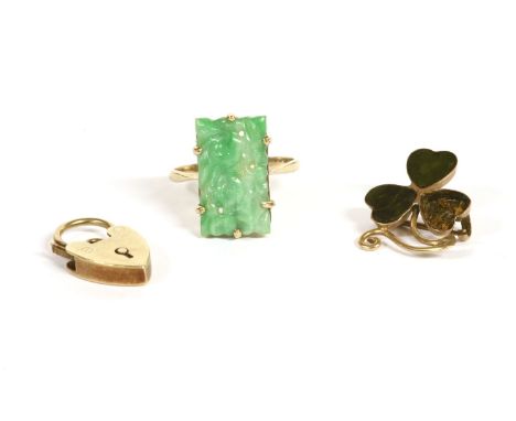 A gold carved jade plaque ring, marked 9ct, claw set, 2.84g, and a 9ct gold hardstone shamrock brooch, (one stone deficient),