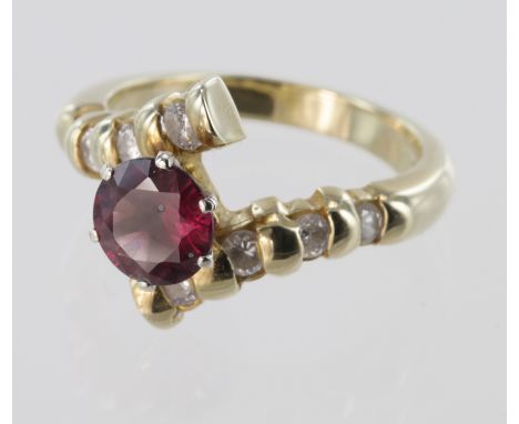 Ladies 14kt dress ring, with a central 7mm Ruby in a crossover setting, each side set with four brilliant cut diamonds of app