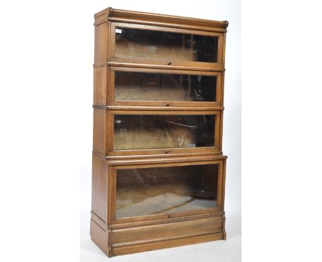 An early 20th century upright four sectioned golden oak lawyers / barristers bookcase by Globe Wernicke. The base with plinth