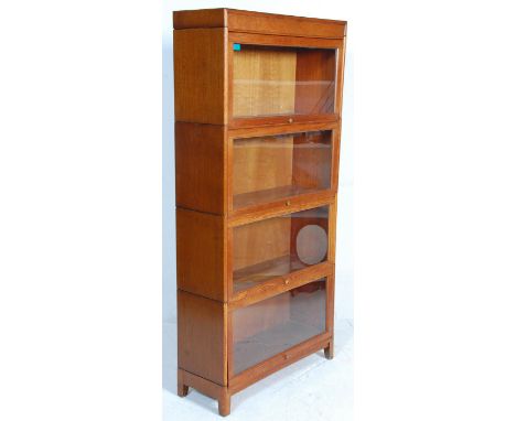 An early 20th century upright four sectioned golden oak lawyers / barristers bookcase. The base with squared, stub legs havin