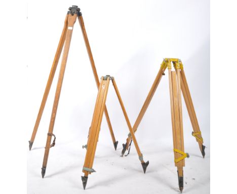 A set of 3 retro 20th century wooden and cast metal surveyors tripod stands. Each with tapering wooden&nbsp; legs, 2 with ext