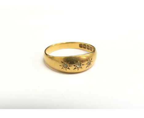 An 18ct gold ring with three small diamonds in star settings. Size P, 3.5g 