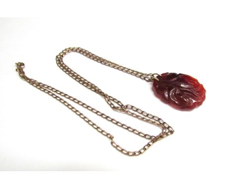 A carved red jade pendant with bird decoration 3.5cm x 2.5cm hung on a gold chain stamped 333, 66cm long, 6.5g 