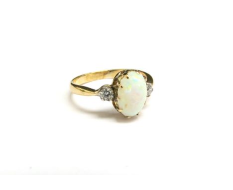 An 18ct gold opal and diamond ring, the oval cabochon opal flanked by diamonds. Size L/M, 2.3g 
