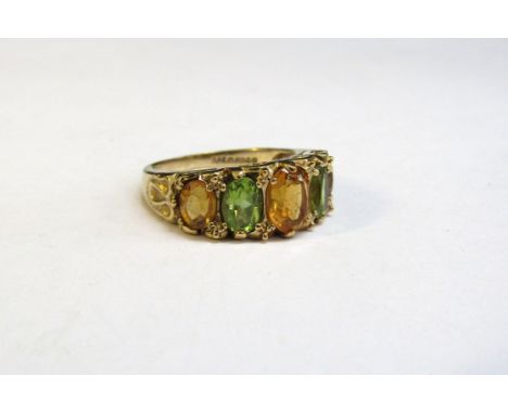 A 9ct gold ring set with alternate peridot and citrine in scroll mount. Size K/L, 3.7g 