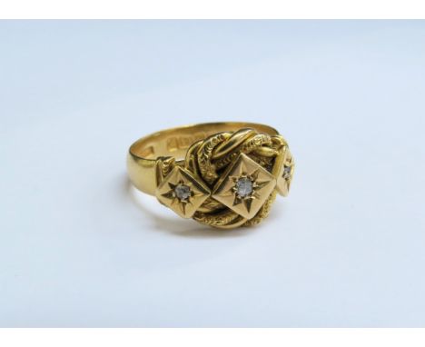 An 18ct gold ring with three diamonds on a "knot" mount. Size N, 7.1g 