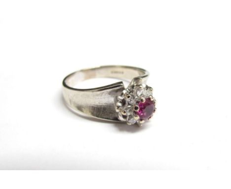 An 18ct white gold ring, London 1891, the central ruby framed by diamonds. Size R, 5.8g 