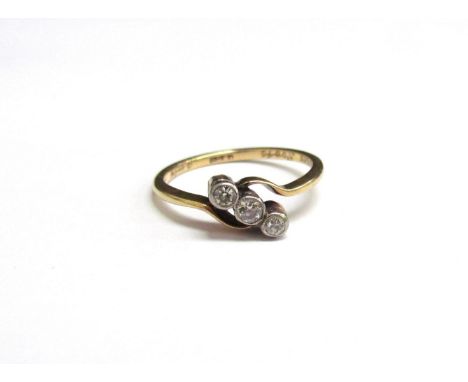 A gold three stone diamond crossover ring. Size M, 2g 