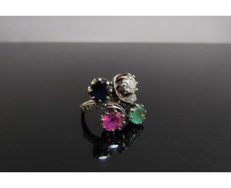 An unmarked gold ring, two diamond set swirls set each side with a diamond, sapphire, emerald and ruby 0.50ct each stone appr